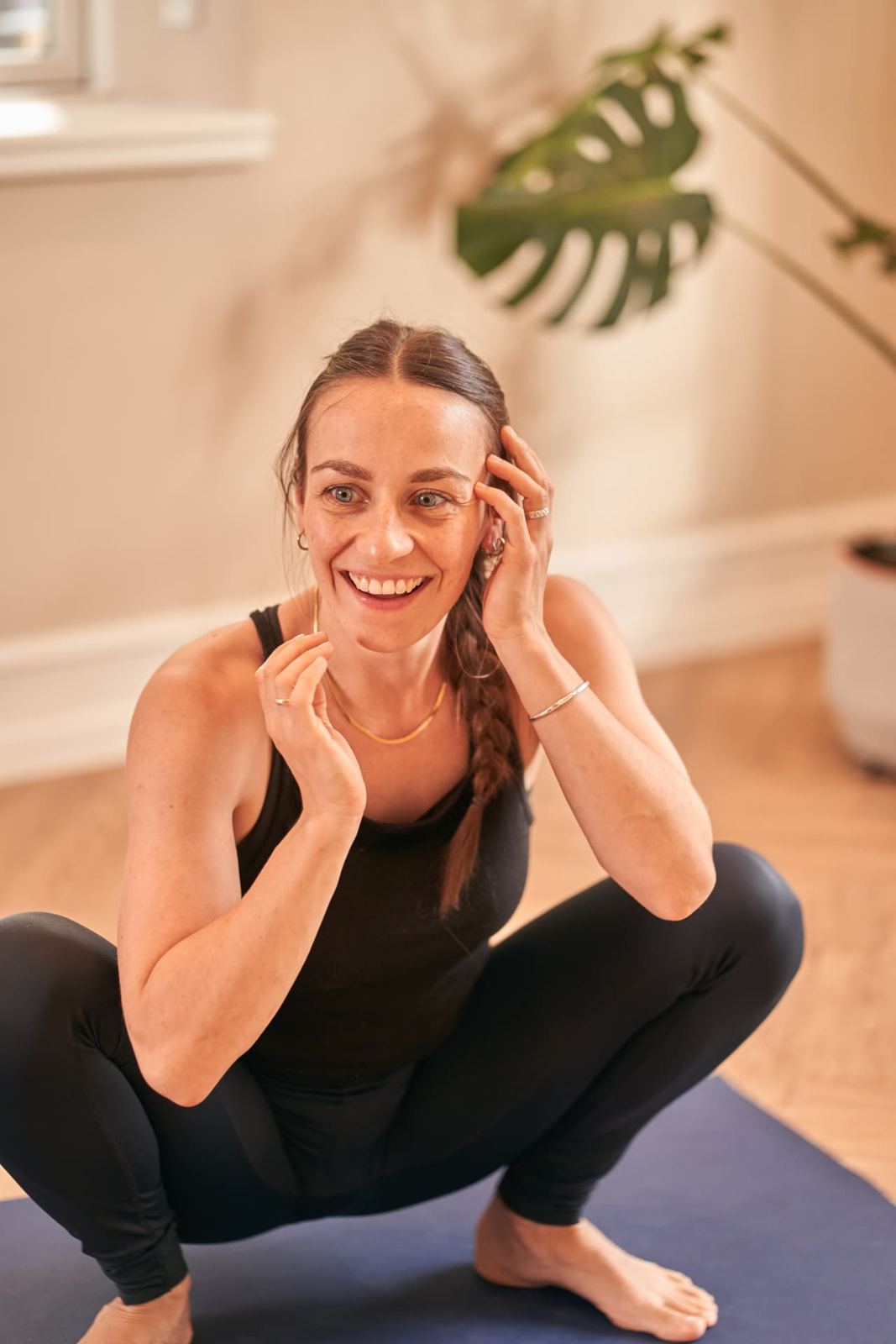 Rikke griner i dyb squat på måtten